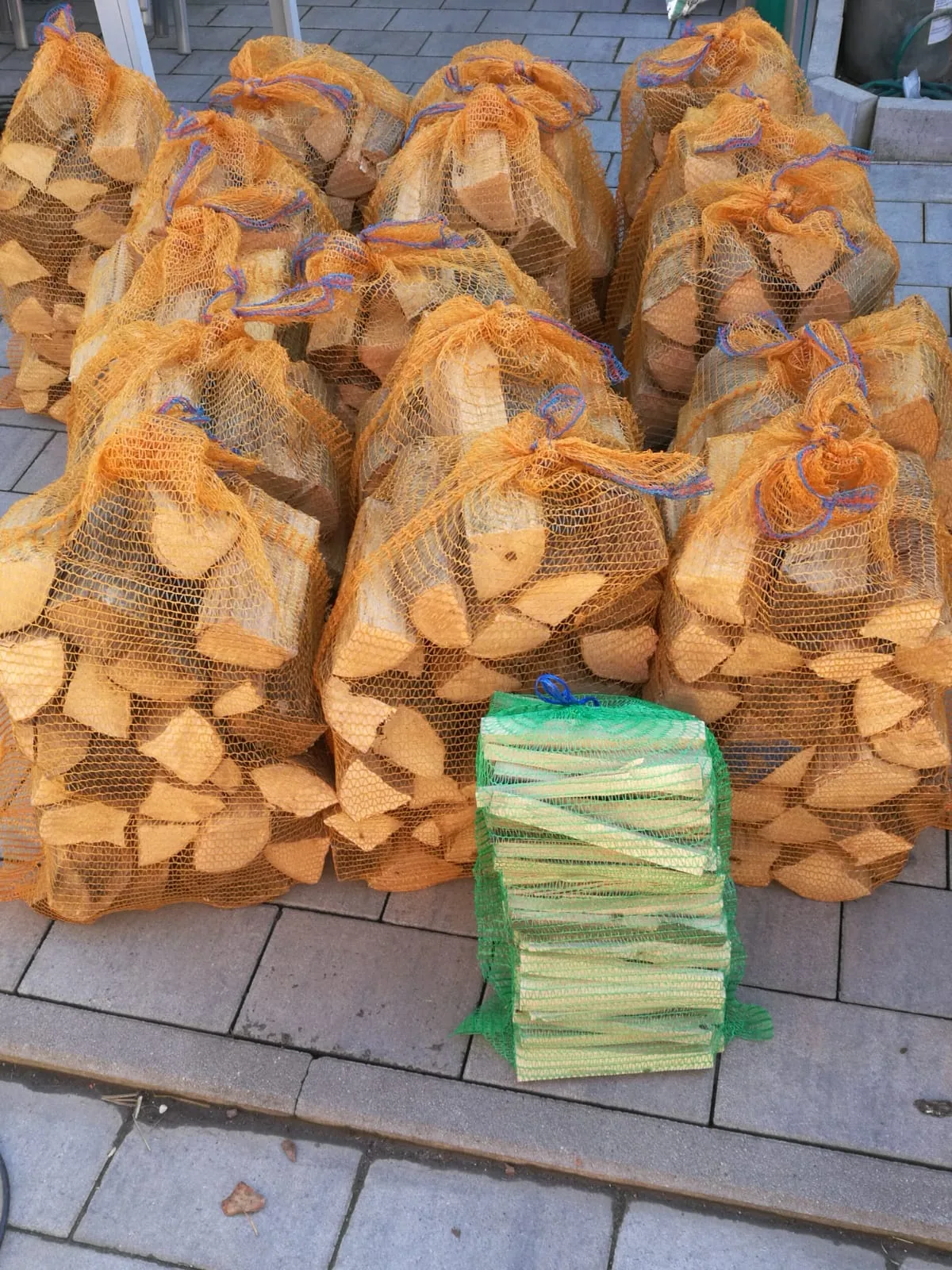 Brennholz in Netzsäcken und Anzündholz-Bündel